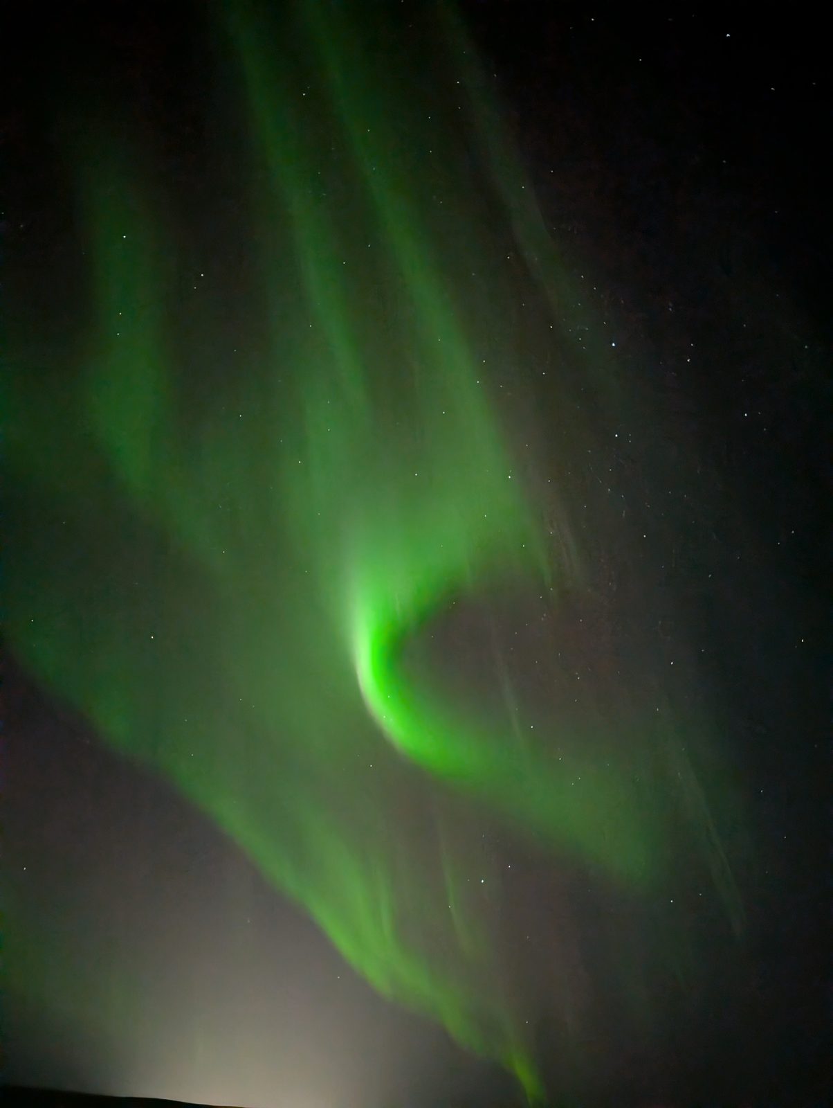 地平線の光とオーロラの渦 Aurora corona swirl above the horizon glow, Iceland