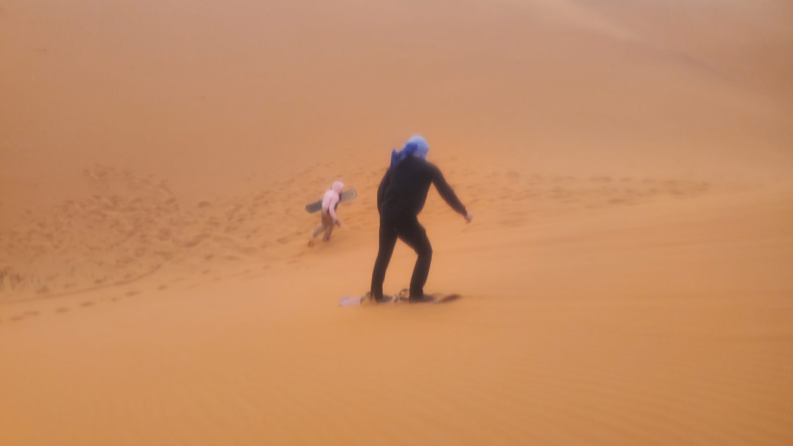 夕暮れのエルグ・シェビ砂丘でサンドボーディング Sandboarding on Erg Chebbi dunes at dusk, Merzouga